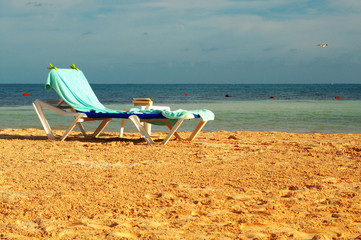 Fototapeta na wymiar sun chair on the sandy beach 