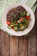 Black bean burger with a salad of fresh vegetables closeup. Vertical top view
