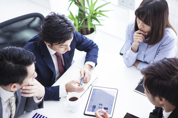 Four young businessmen are meeting in the office