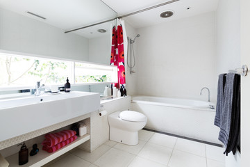 Contemporary white bathroom of mosaic and terrazzo tiles with red accent