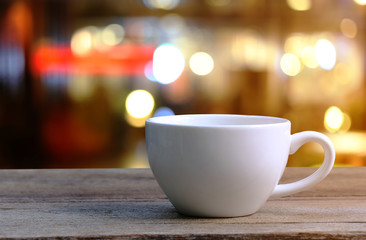 White Coffee cup on wooden table in coffee shop blur background.