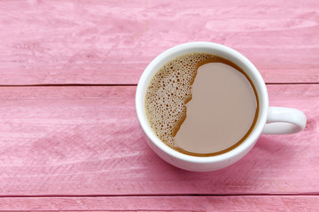 hot coffee in a white Coffee cup on Pink wooden table.