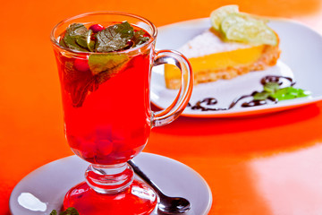 Herbal tea with fruit dessert in the background