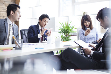 Young businessman is looking at the smart phone in the office
