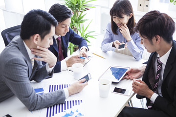 Four young businessman has been meeting with the communication equipment in the office