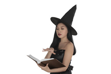 Asian sexy witch creating a spell at the book