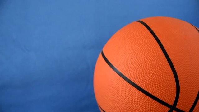 close up of moving basketball and copy space on blue chroma key background