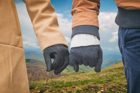 Couple holding hands outdoors.