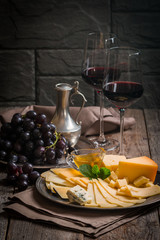 Refined still life of red wine, grapes and cheese
