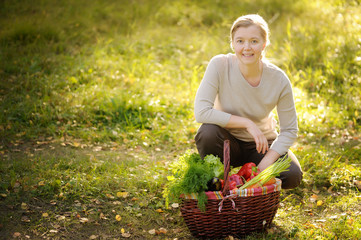 Close-up of a woman with freshly harvested vegetables.