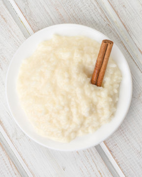 Overhead Shot Pile Of Rice Pudding On Porcelain Plate, On Wood