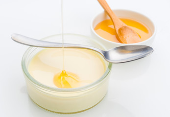 Honey jet falls on homemade custard, isolated