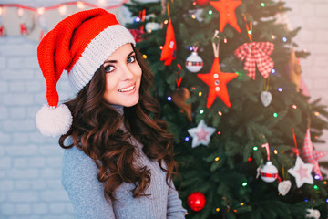 Beautiful woman in a Santa hat on Christmas background.