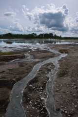 Lake with reflection of the sky and steamy hotsprings in Uzon Caldera, Kamchatka, Russia