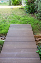 Wooden plank bridge walkway on lawn