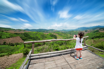 Fototapeta na wymiar Little girl taking a photograph on viewpoint, Nan Thailand
