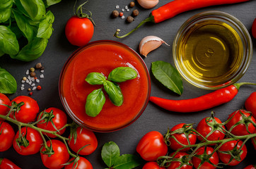Tomato sauce with basil on black background, top view