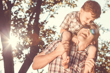 Father and son playing at the park at the day time.
