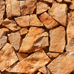 Wall of brown natural stones, wall background