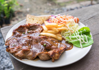 Pork steak tasty with salad vegetarian on wood table