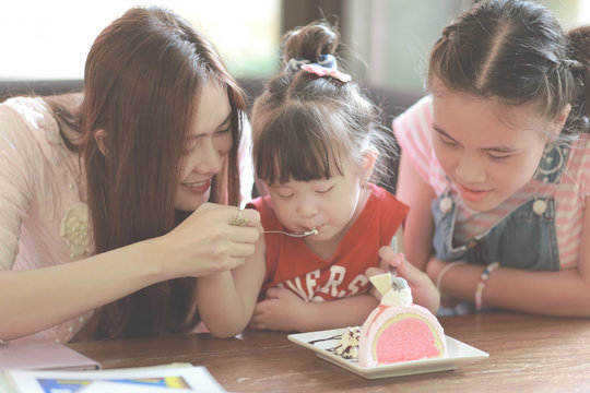 Family Eating Cake In Restaurant