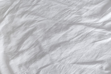Fototapeta na wymiar Wrinkles on crumpled white cotton sheets textire