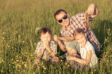 Father and children walking on the road at the day time.