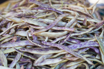 Pile of yellow red string beans at farm market. Runner beans. String beans background