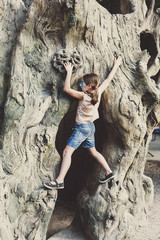 Girl child outdoors climb tree with butterfly face painting