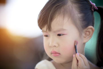Little girl makeup her face
