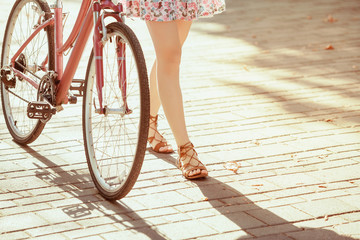 Naklejka premium The young girl with bicycle in park