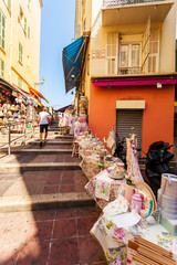Narrow street with tables and decorated in Provencal style in old part of Nice. Excellent French city with a touch of Provence.
