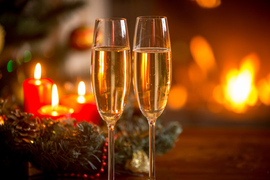 Closeup image of glasses of champagne in front of Christmas wrea