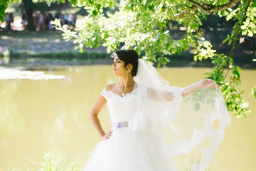 Fototapeta na wymiar Beautiful bride on river bank