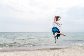 Fototapeta na wymiar Happy beautiful young girl jumping