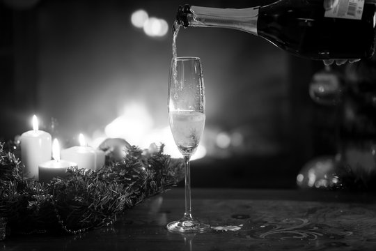 Black and white image of champagne flute being filled from bottl