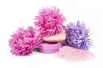 Obraz na płótnie Canvas Bath salt, soap and shampoo in pink and violet color with flowers