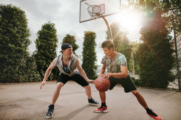 Obraz premium Two young men having a game of basketball