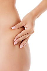 The woman squeezes a skin on a hip for check on a cellulitis.