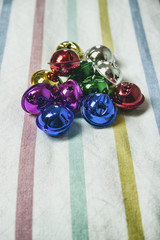 Fondo de rayas de colores con un montón de cascabeles de colores variados