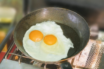 Fried eggs in a pan on a gas stove