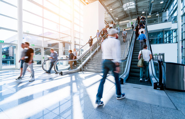 blurred people walking in a modern hall