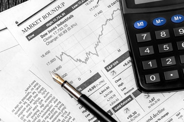 Pen and calculator on the business newspaper