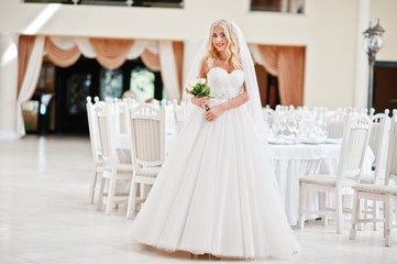 Fototapeta na wymiar Elegant blonde blue eyes fashion bride at great wedding hall