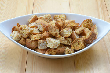 Homemade french croutons in white bowl close up
