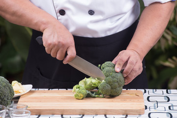 Chef cutting broccoli for cooking