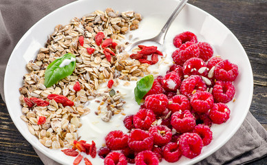 Healthy breakfast. Muesli, goji berries, yogurt on rustic wooden