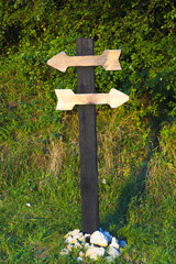 Wooden pole with two wooden planks in form of arrows for inscriptions. Wooden directional sign with two empty arrows