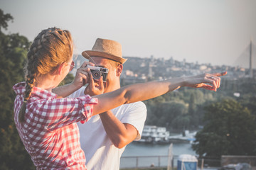 Couple taking photos with retro camera outdoors