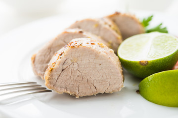 Sliced lime pork tenderloin on white background close up. Healthy food.
